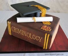 a graduation cake made to look like a book with a mortar and diploma on top