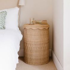 a white bed sitting next to a wicker basket