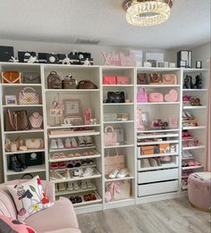 a room filled with lots of white shelves covered in purses and handbag's