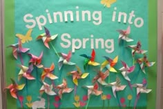 a bulletin board with paper birds and flowers on it that says, spinning into spring