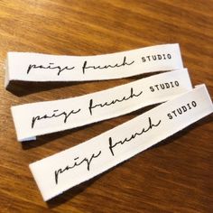 three white fabric name tags on a wooden table