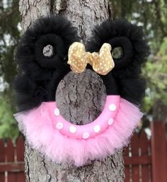 a black and pink wreath hanging on a tree