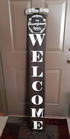 a welcome sign in front of a door with the word welcome written on it's side