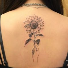 a woman's back with a sunflower tattoo on it