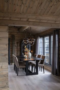 a dining room table with chairs and a chandelier hanging from it's ceiling