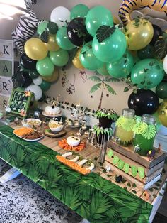 a jungle themed party with balloons and desserts