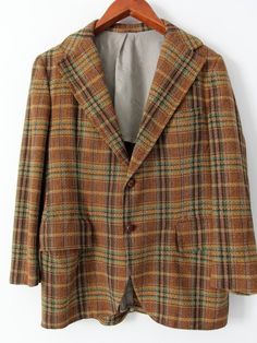 A men's 1950s vintage tweed blazer. The wool plaid check sport coat features a single vent and two button closure. The cuffs are detailed with brown leather buttons. Covered pockets sit on the waist. The yoke of the jacket is lined as well as the sides to include an interior pocket. • plaid tweed sport coat• single vent• 2 buttonCONDITIONIn good condition. There are some small worn spots on the wool, with a small hole on the shoulder. Approximate Fit: Medium 38 - 40MEASUREMENTSBust:            4 Plaid Wool Sport Coat With Lapel Collar, Plaid Wool Sport Coat With Welt Pockets, Wool Plaid Sport Coat With Welt Pockets, Winter Plaid Tweed Jacket With Welt Pockets, Tailored Plaid Sport Coat For Fall, Winter Plaid Sport Coat With Welt Pockets, Brown Single Button Tweed Jacket For Fall, Plaid Wool Tweed Jacket With Notch Lapel, Fitted Plaid Tweed Jacket With Single Button