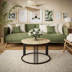 a living room with green couches and pictures on the wall above it, along with a coffee table