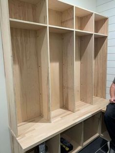 a man sitting in front of some wooden shelves