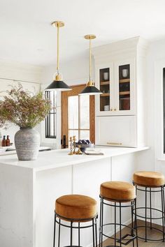 three stools sit at the center of a kitchen island