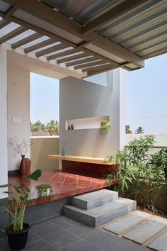 an outdoor area with concrete steps and potted plants on the other side of the building