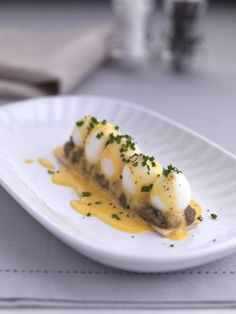 a white plate topped with food covered in cheese