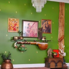 a green wall with paintings and other items on it, including a pipe in the corner