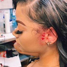 a woman with red ink on her left ear and the word love behind her ear