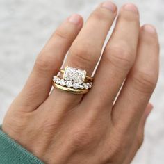 a woman's hand with two gold and white wedding rings on it, one is holding the other