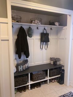 a coat rack with baskets and coats hanging on it's sides next to a door