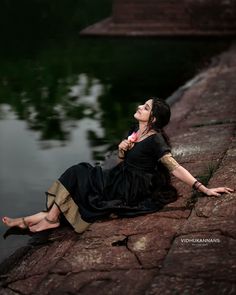 a woman laying on the ground next to water