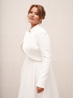 a woman in a white dress posing for a photo with her hands on her hips