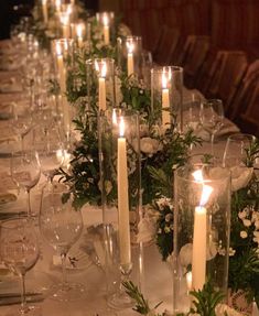 a long table is set with candles and flowers for a formal dinner or wedding reception