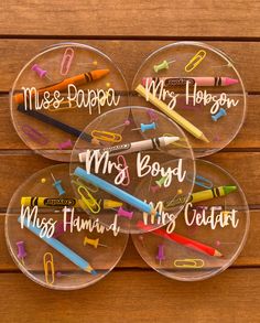 four clear plastic personalized name plates with crayons and pencils on them