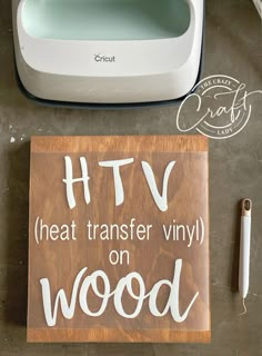 a wooden sign that says htv heat transfer vinyl on wood next to a cricut machine