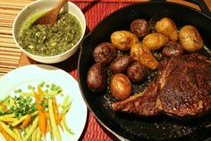 there is a steak and potatoes in the pan on the table next to other foods