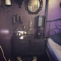 a bedroom with purple walls and a black dresser in front of a mirror on the wall