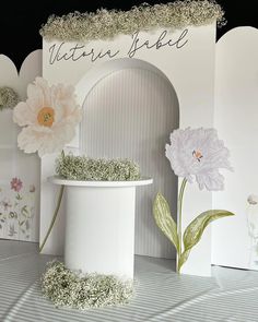 there is a white vase with flowers in it on the table next to two greeting cards