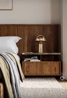 a bed with a wooden headboard and night stand on top of it in a bedroom