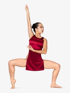 a woman in a red leotard is doing a yoga pose with her hands up