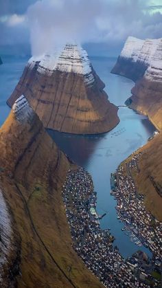 an aerial view of the mountains and river in iceland, with snow on them as far as the eye can see