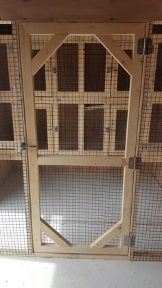 the inside of a wooden and wire cage with doors open to allow people to enter