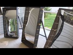 three mirrors sitting on top of a wooden floor next to a window in front of a house