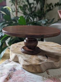 a wooden cake stand sitting on top of a table