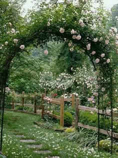 a garden with white flowers on it and a wooden fence in the middle is surrounded by greenery