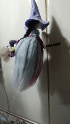 a doll hanging from the side of a door with a hat on it's head