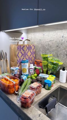 the kitchen counter is full of fresh produce and groceries, including carrots, cucumbers, celery, tomatoes, onions, green beans, and more