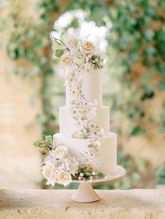 a wedding cake with white flowers and greenery