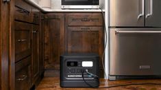 an appliance is plugged into the wall in front of a stainless steel refrigerator