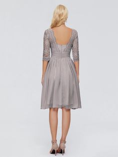 the back view of a woman wearing a short grey dress with sheer sleeves and lace detailing