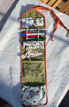 an orange and white tie is hanging on a table with several different pieces of fabric