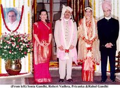 three men and two women standing in front of a decorated stage