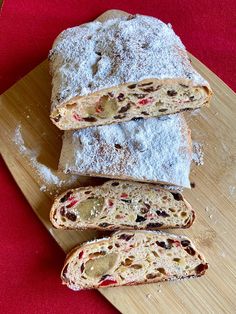 three pieces of bread on a cutting board with powdered sugar and cranberries