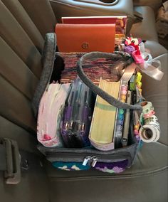 an open suitcase sitting in the back seat of a car filled with books and other items