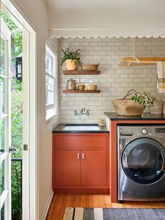 a washer and dryer in a small room with wood flooring on the walls