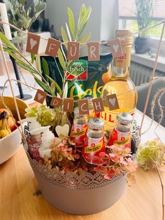 a basket filled with drinks and flowers on top of a table