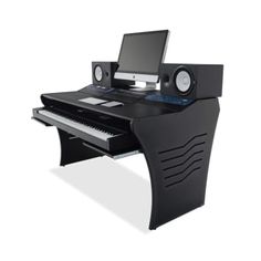 a computer desk with a keyboard, monitor and speakers on it's sides in front of a white background