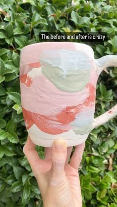 someone is holding up a coffee mug that has been painted with pink and green paint