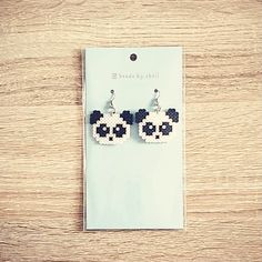 a pair of mickey mouse earrings sitting on top of a wooden table next to a card