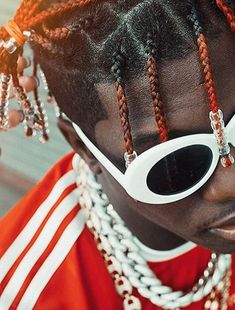 a woman with sunglasses and braids on her head, wearing red and white clothing